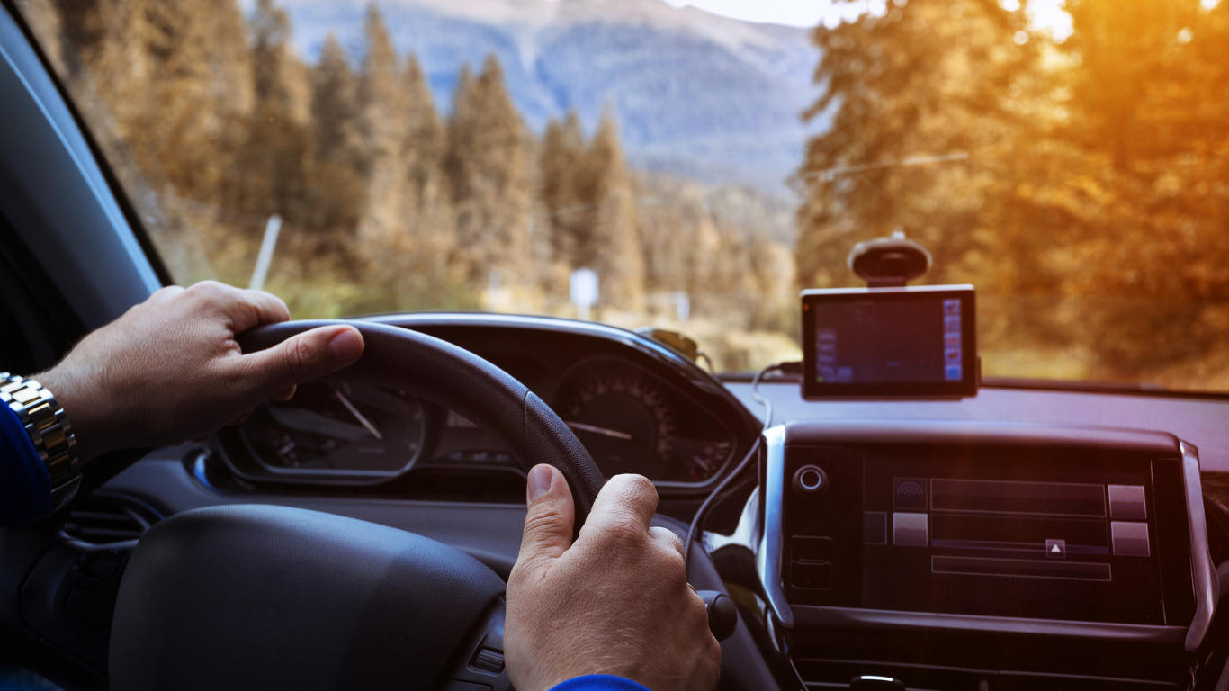 Driver hands on steering wheel during comfortable family road trip.