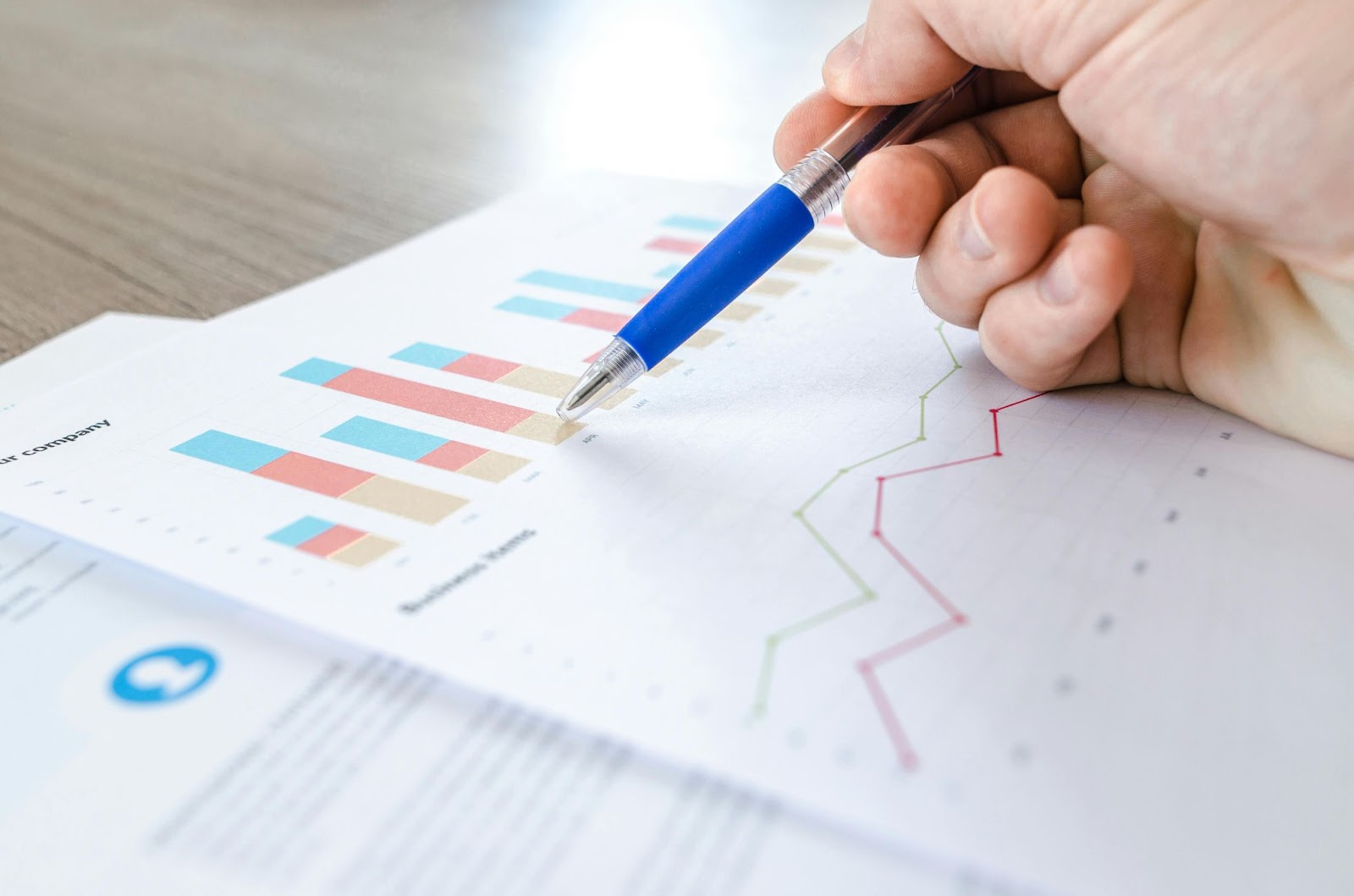 A man inspecting finance documents depicting graphs and charts.